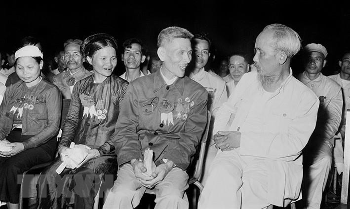 Chủ tịch Hồ Chí Minh nói chuyện thân mật với Anh hùng lao động Nguyễn Phúc Đồng (ngành Quân giới) và nữ anh hùng Nguyễn Thị Năm (dệt Nam Định) trong buổi họp mặt các Anh hùng, Chiến sĩ thi đua toàn quốc. (Ảnh: Tư liệu/TTXVN)
