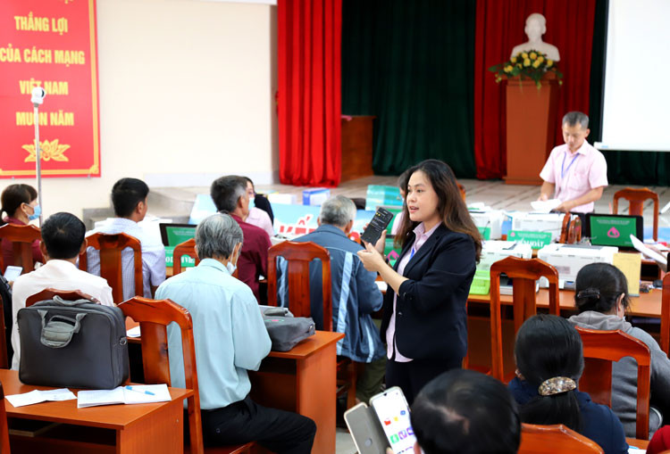 Bà Trương Thị Lệ Phương - Phó Giám đốc Phòng Giao dịch Ngân hàng CSXH thành phố Bảo Lộc hướng dẫn khách hàng cài đặt ứng dụng Giáo dục tài chính