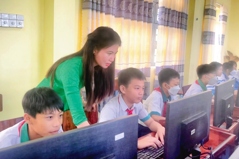 Cô giáo Lưu Thị Vương Anh cần mẫn bên học trò trong giờ Tin học