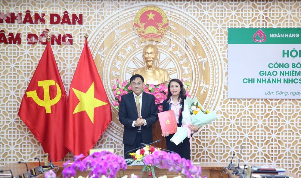 Ông Võ Ngọc Hiệp - Ủy viên Ban Thường vụ Tỉnh ủy, Phó Chủ tịch UBND tỉnh Lâm Đồng trao quyết định của Tổng Giám đốc NHCSXH Việt Nam và chúc mừng bà Nguyễn Thị Ngọc Thu