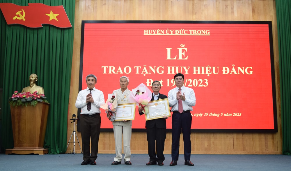 Đồng chí Trần Đình Văn - Phó Bí thư Thường trực Tỉnh ủy, Trưởng Đoàn ĐBQH tỉnh và đồng chí Bùi Sơn Điền – Bí thư Huyện ủy Đức Trọng, trao tặng Huy hiệu Đảng cho các đảng viên