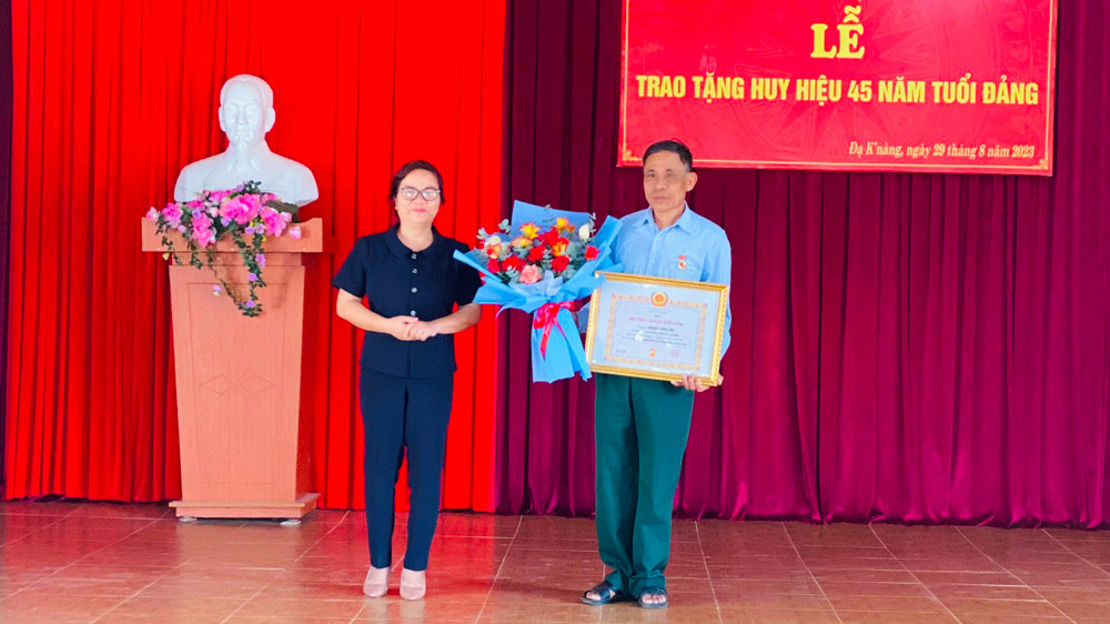 Đồng chí Phó Bí thư Thường trực Huyện ủy trao tặng Huy hiệu Đảng cho đảng viên Nguyễn Đình Cầm 45 năm tuổi Đảng
