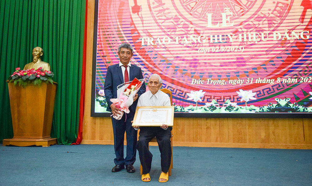 Đồng chí Bùi Sơn Điền – Bí thư Huyện ủy Đức Trọng, trao Huy hiệu 75 năm tuổi Đảng cho đảng viên Nguyễn Ưu