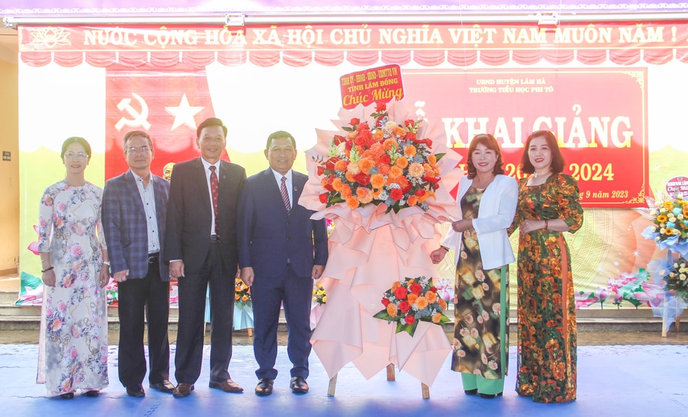 Đồng chí K’ Mák - Ủy viên Ban Thường vụ Tỉnh ủy, Phó Chủ tịch HĐND tỉnh tặng hoa chúc mừng thầy và trò Trường Tiểu học Phi Tô