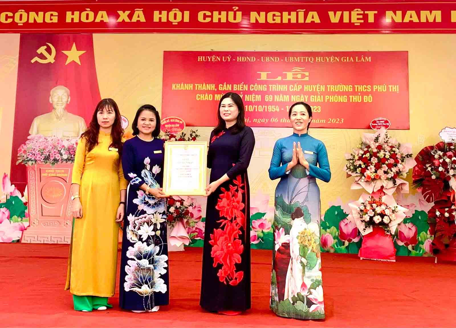 Chủ tịch UBND huyện Gia Lâm Đặng Thị Huyền trao chứng nhận Công trình chào mừng kỷ niệm 69 năm Ngày Giải phóng Thủ đô cho Ban Giám hiệu Trường THCS Phú Thị. Ảnh: Ánh Dương