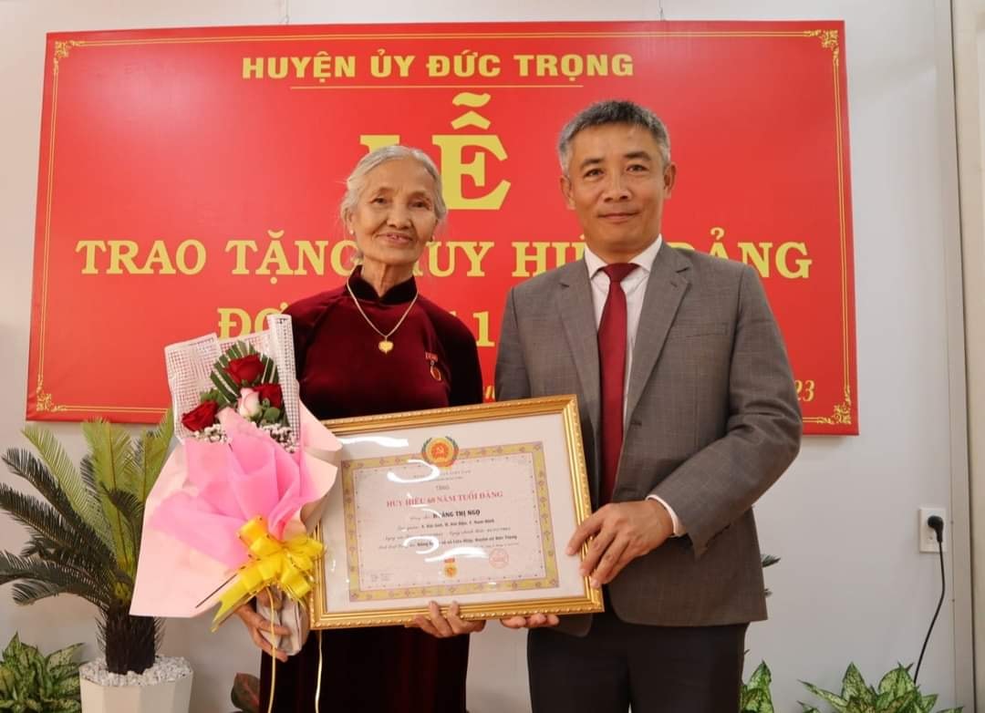 N.MINHĐồng chí Bùi Sơn Điền – Bí thư Huyện ủy Đức Trọng, trao Huy hiệu 60 năm tuổi Đảng cho đảng viên Hoàng Thị Ngọ