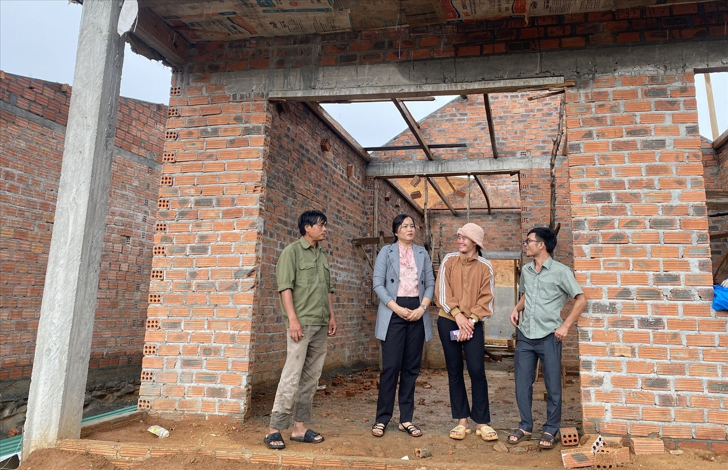 Chi Y Hồng Vân (thứ 2 từ phải sang) phấn khởi khi được hỗ trợ đất và tiền xây dựng nhà tại khu giãn dân thôn Đăk Xina