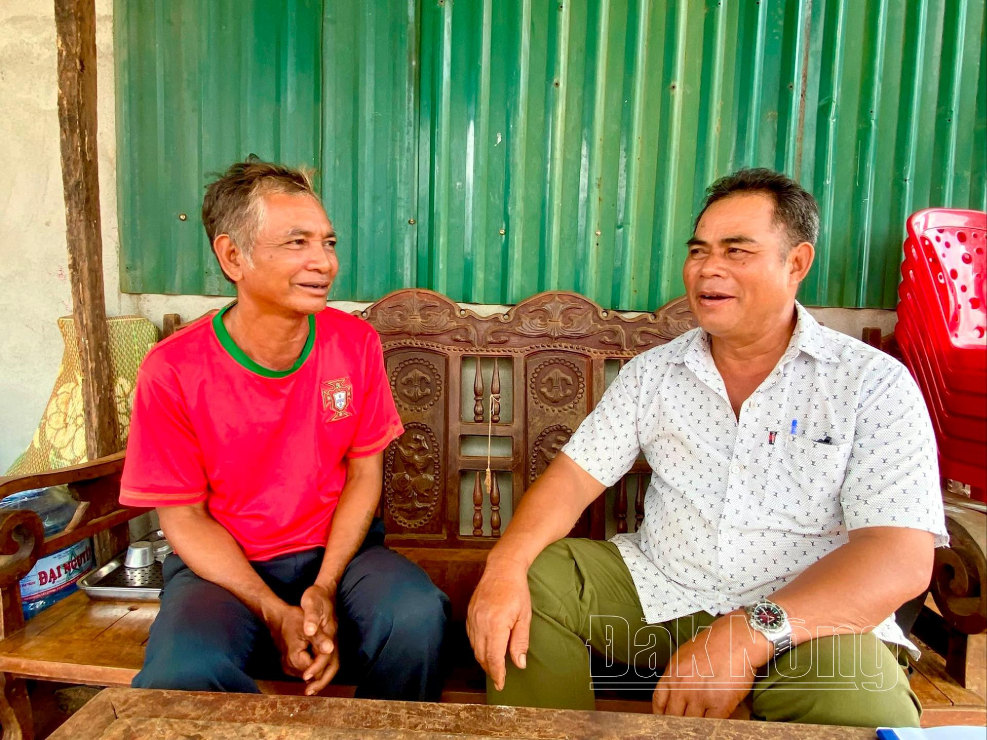 Ông Y Bang (bên phải), Trưởng bon Đắk Láp tuyên truyền, vận động người dân chung tay giữ gìn đường giao thông NTM kiểu mẫu sáng - xanh - sạch - đẹp