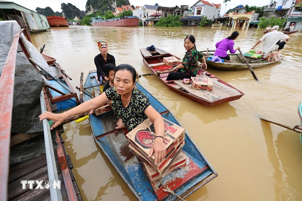 Người dân đến điểm nhận hỗ trợ mỳ tôm, nước uống, bánh mỳ, (Ảnh: Minh Đức/TTXVN)