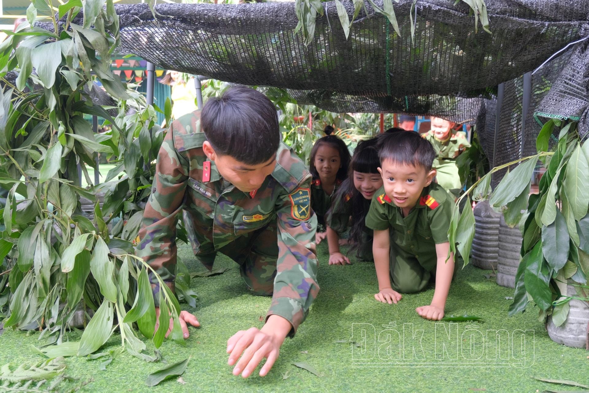 Các em nhỏ cùng các chú bộ đội thực hiện nội dung chui qua chiến hào