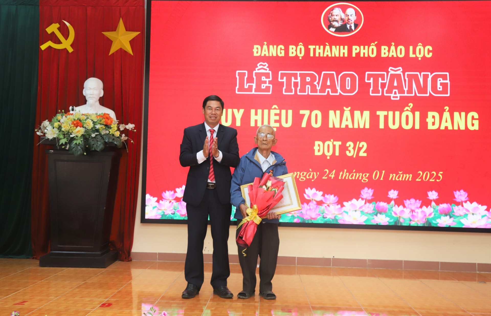 Đồng chí Nghiêm Xuân Đức - Phó Bí thư Thường trực Thành ủy, Chủ tịch UBND TP Bảo Lộc trao tặng Huy hiệu 70 năm tuổi Đảng cho đảng viên