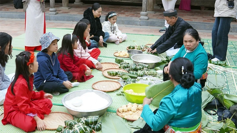 Các em nhỏ được trải nghiệm gói bánh chưng tại Bảo tàng Dân tộc học Việt Nam.