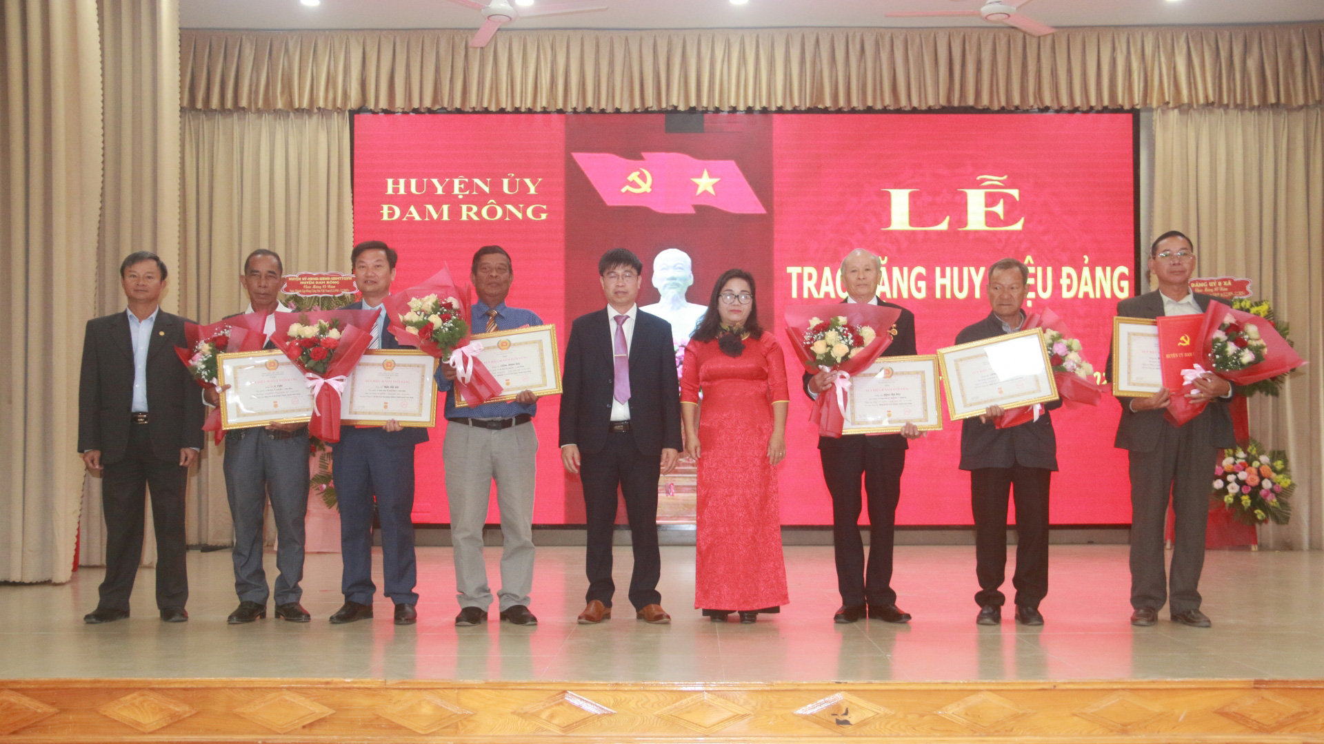Các đồng chí Thường trực Huyện ủy trao Huy hiệu Đảng và tặng hoa chúc mừng các đảng viên được nhận Huy hiệu Đảng