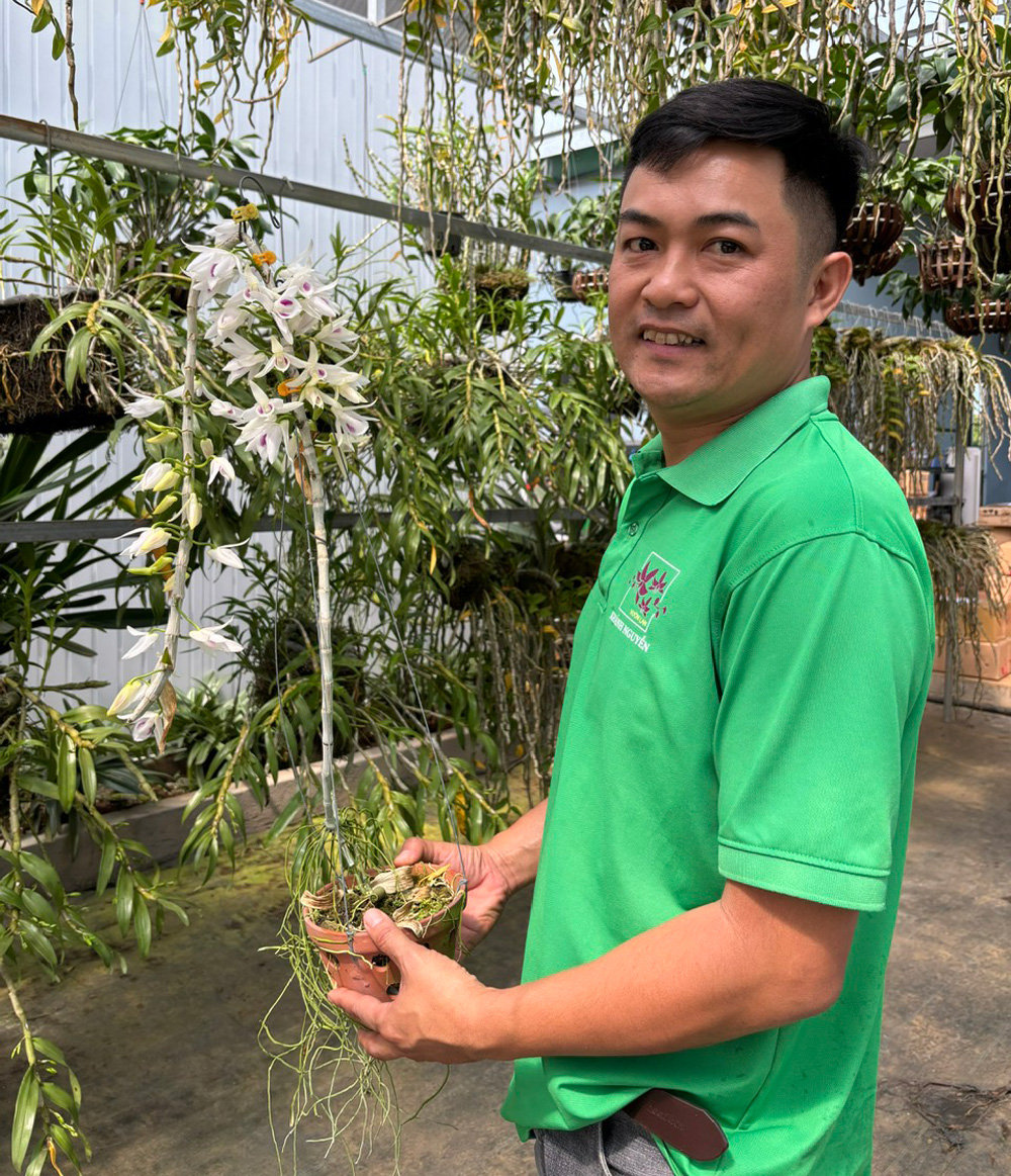 Anh Nguyễn Ngọc Khánh bên một chậu lan xuân