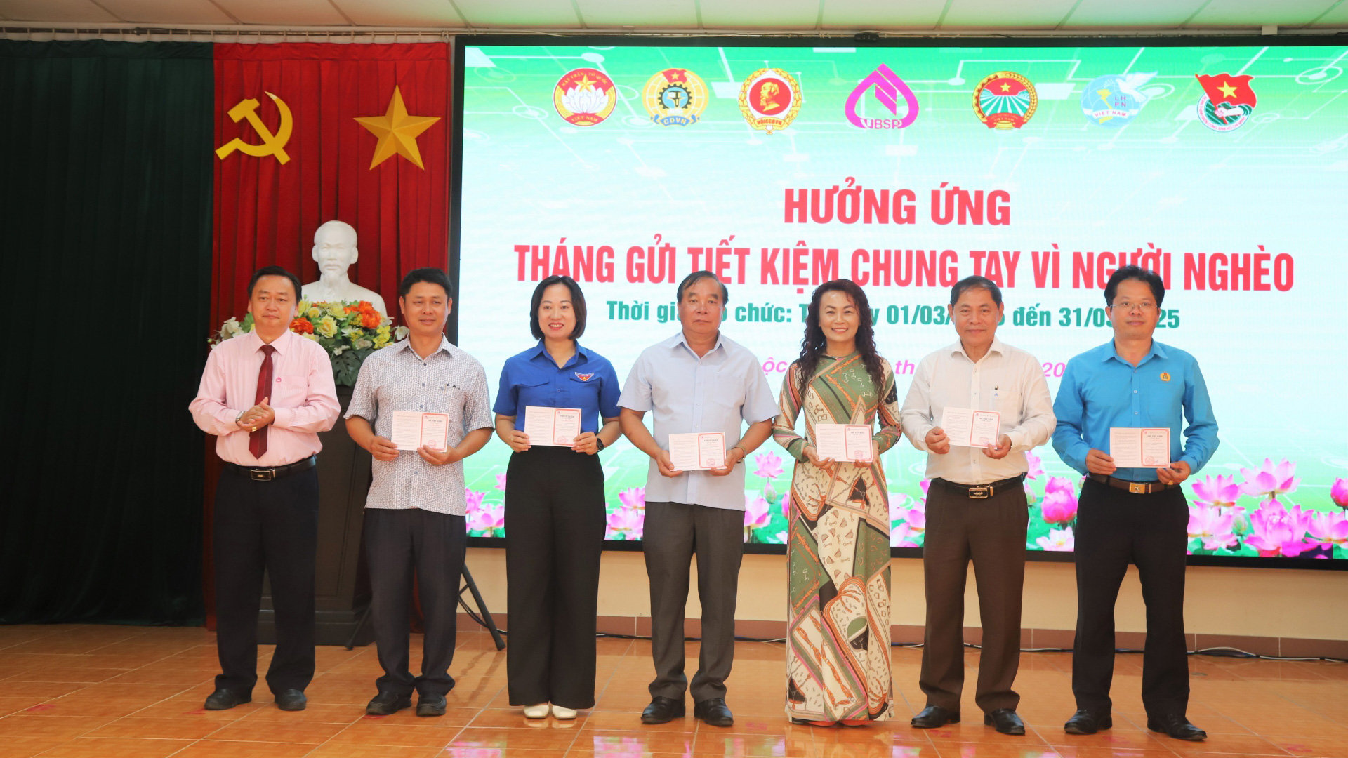 Lãnh đạo Phòng giao dục Ngân hàng Chính sách TP Bảo Lộc trao sổ tiết kiệm cho Ủy ban MTTQ Việt Nam TP Bảo Lộc và các hội, đoàn thể thành phố tham gia gửi tiết kiệm chung tay vì người nghèo