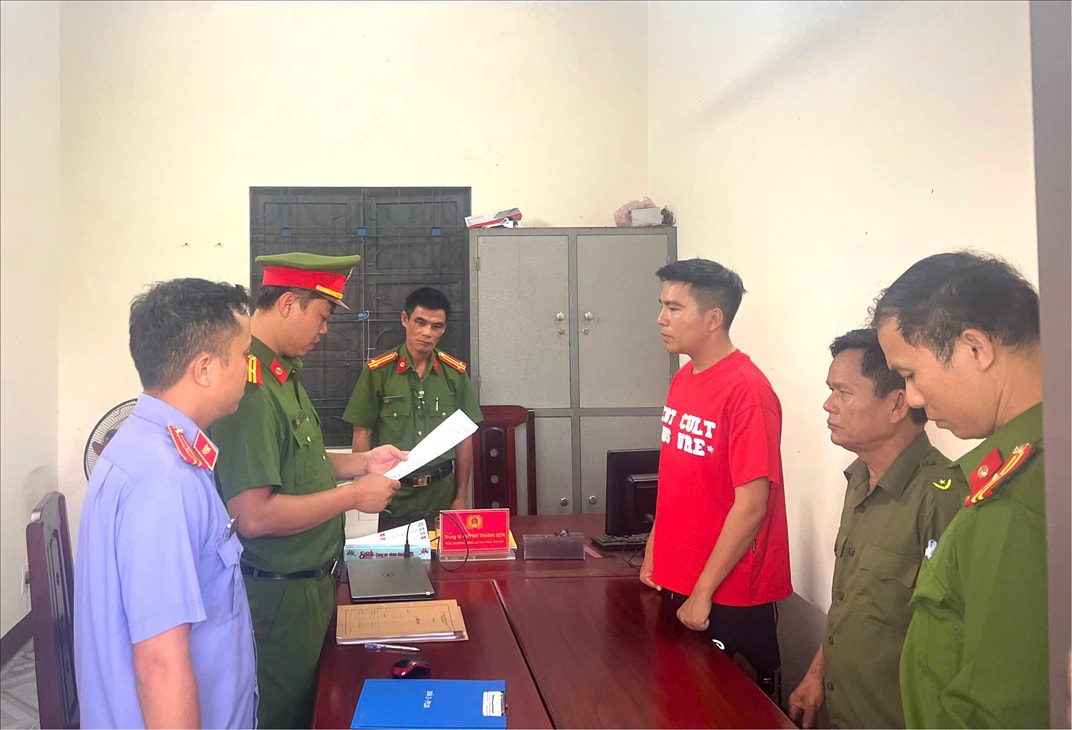 Văn phòng Cơ quan Cảnh sát điều tra Công an tỉnh Quảng Nam tống đạt các quyết định và lệnh đối với Mai Văn Dưỡng (áo đỏ).