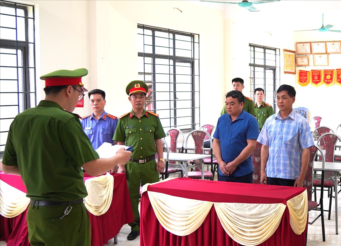 Cơ quan Cảnh sát điều tra Công an tỉnh Bắc Kạn tống đạt quyết định khởi tố đối với Hà Văn Quý (áo kẻ) và Hoàng Văn Duẩn (áo xanh).
