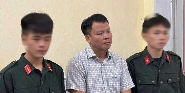 Ông Đồng Xuân Thụ, Tổng biên tập Tạp chí Môi trường và Đô thị Việt Nam (giữa), khi bị giữ khẩn cấp về tội cưỡng đoạt tài sản