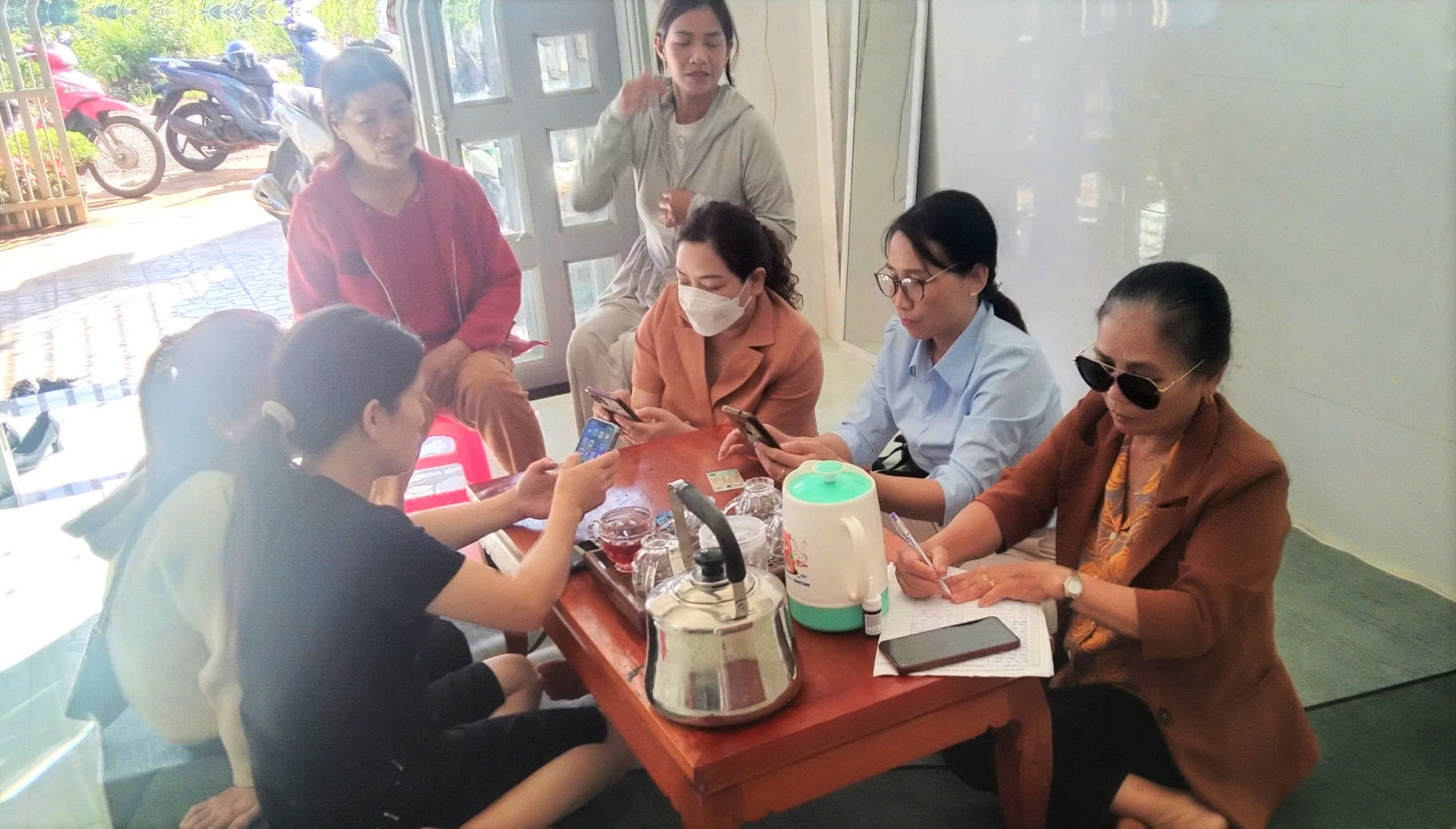 Cán bộ Mặt trận, các hội, đoàn thể xã Đam Bri hỗ trợ, hướng dẫn người dân góp ý Hiếp pháp qua ứng dụng VNeID