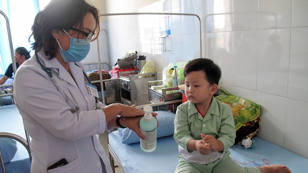 Bác sĩ hướng dẫn bệnh nhi rửa tay sau khi chơi đồ chơi để phòng bệnh tay chân miệng
