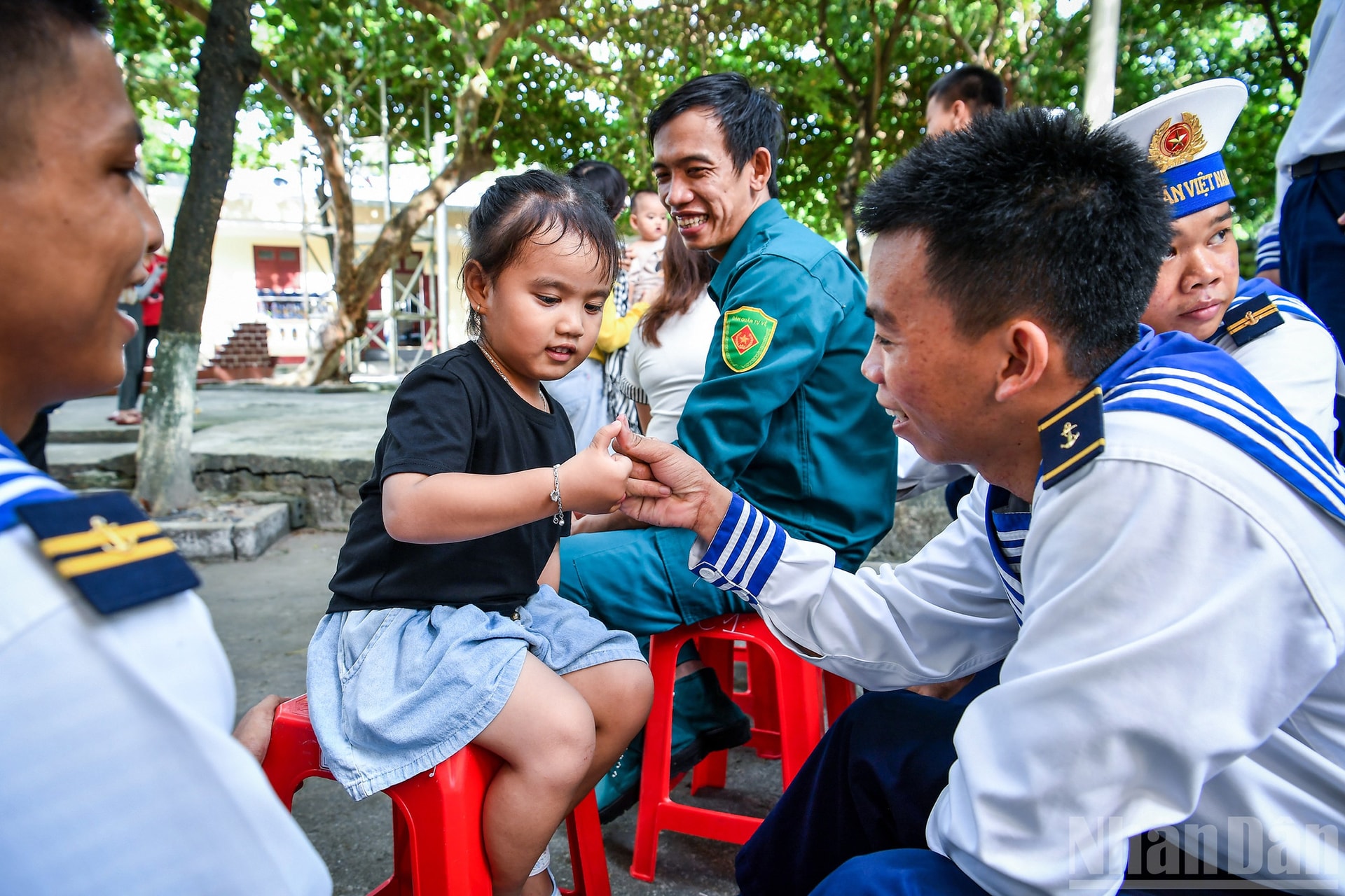 Những lúc rảnh, những anh lính trẻ chơi đùa cùng các em bé trên đảo để vơi đi nỗi nhớ nhà. ndo_br_3a.jpg