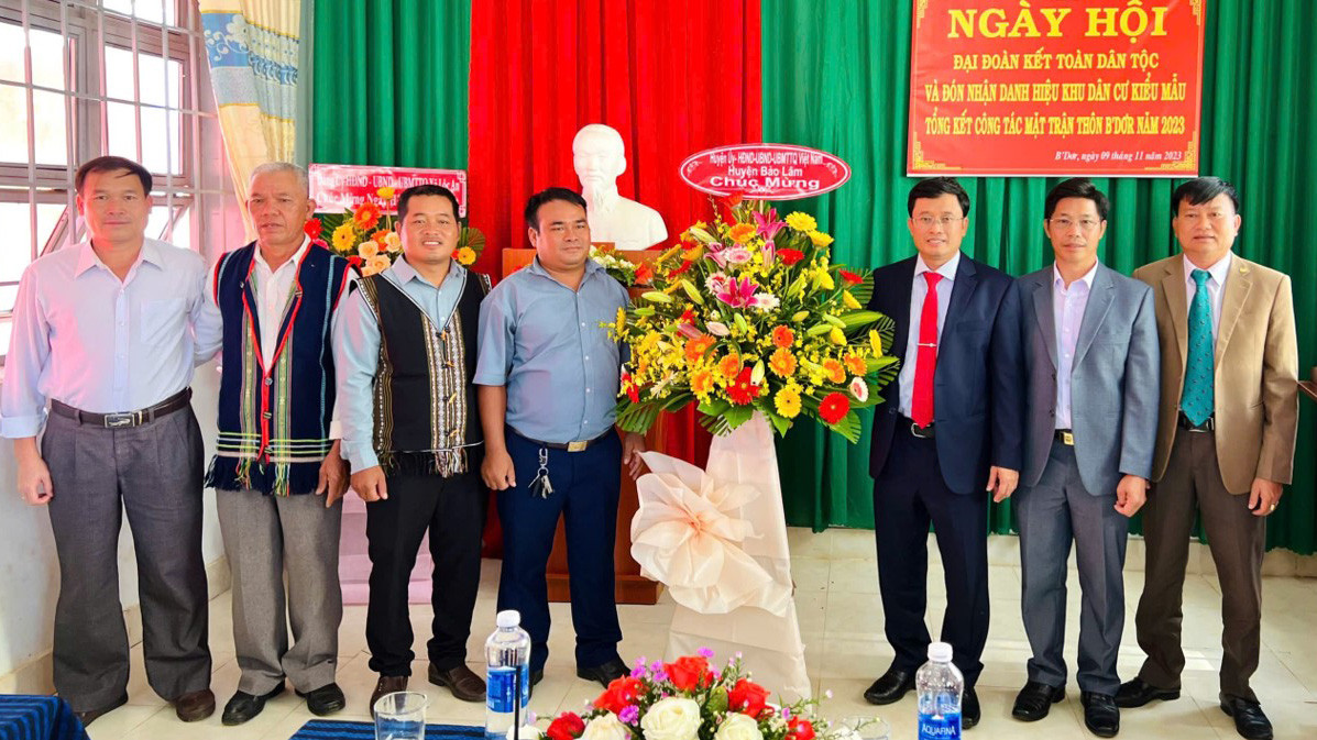 Đồng chí K’ Boer cùng với ban thôn nhận hoa chúc mừng của lãnh đạo huyện Bảo Lâm và xã Lộc An
