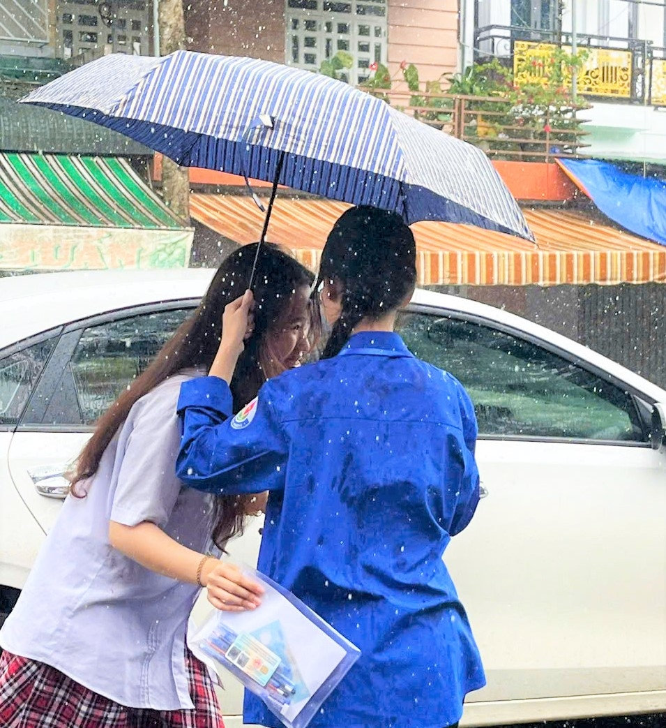 Thanh niên tìn nguyện che dù cho thí sinh vào phòng thi tại điểm thi trường THPT Bảo Lộc
