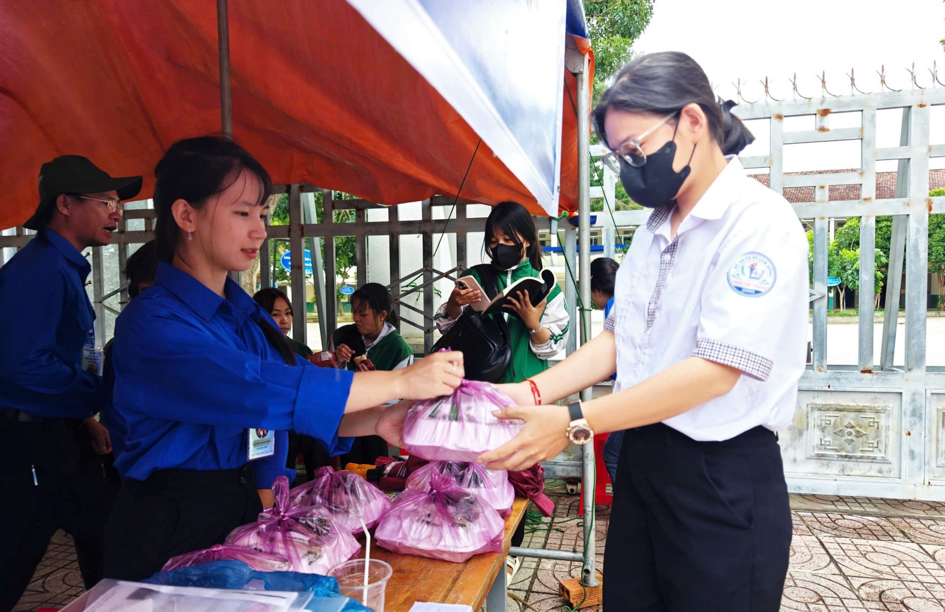 Thanh niên tình nguyện tại điểm thi trường THPT Lộc Thằng phát tặng cơm trưa miễn phí cho thí sinh