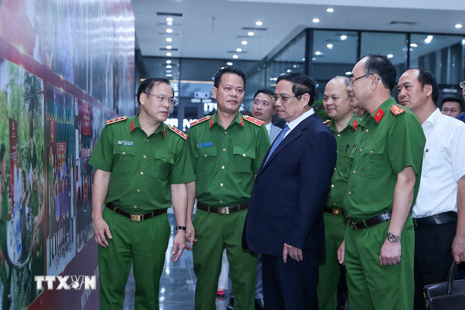 Thủ tướng Phạm Minh Chính xem hình ảnh về công tác giám định ADN hài cốt liệt sỹ. (Ảnh: Dương Giang/TTXVN) ttxvn-thu-tuong.jpg