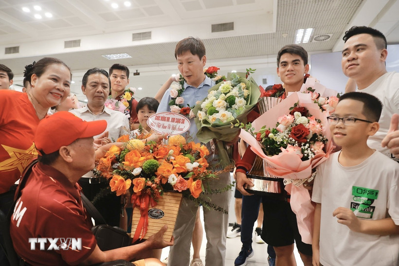 Người hâm mộ tặng hoa thầy trò huấn luyện viên Kim Sang Sik. (Ảnh: Minh Quyết/TTXVN)