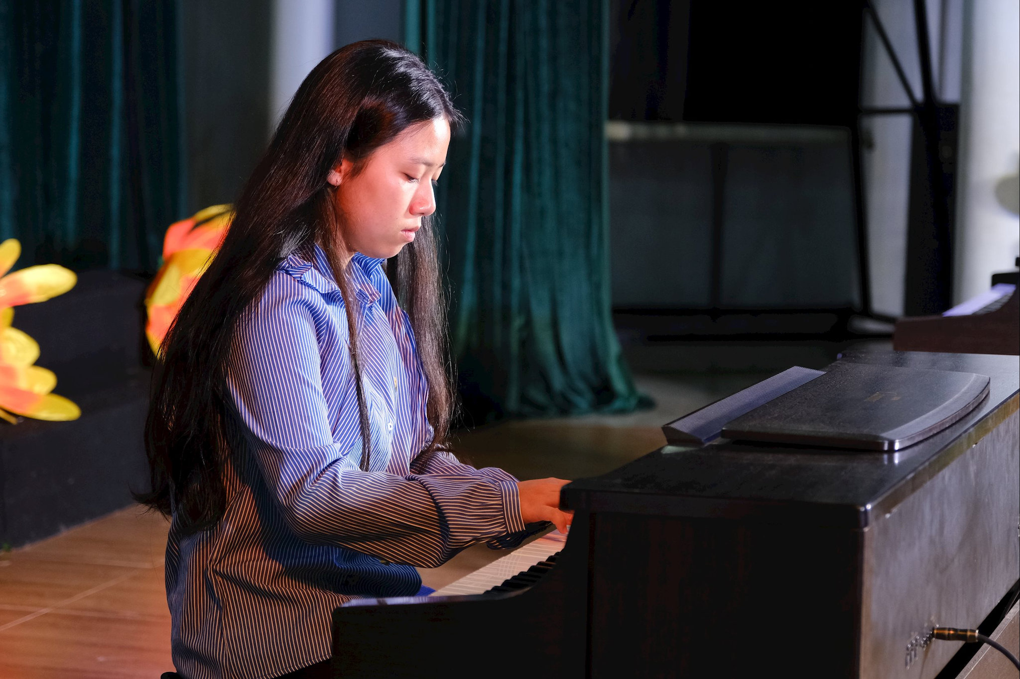 Học sinh biểu diễn piano với sự tập trung và cảm xúc trong từng nốt nhạc