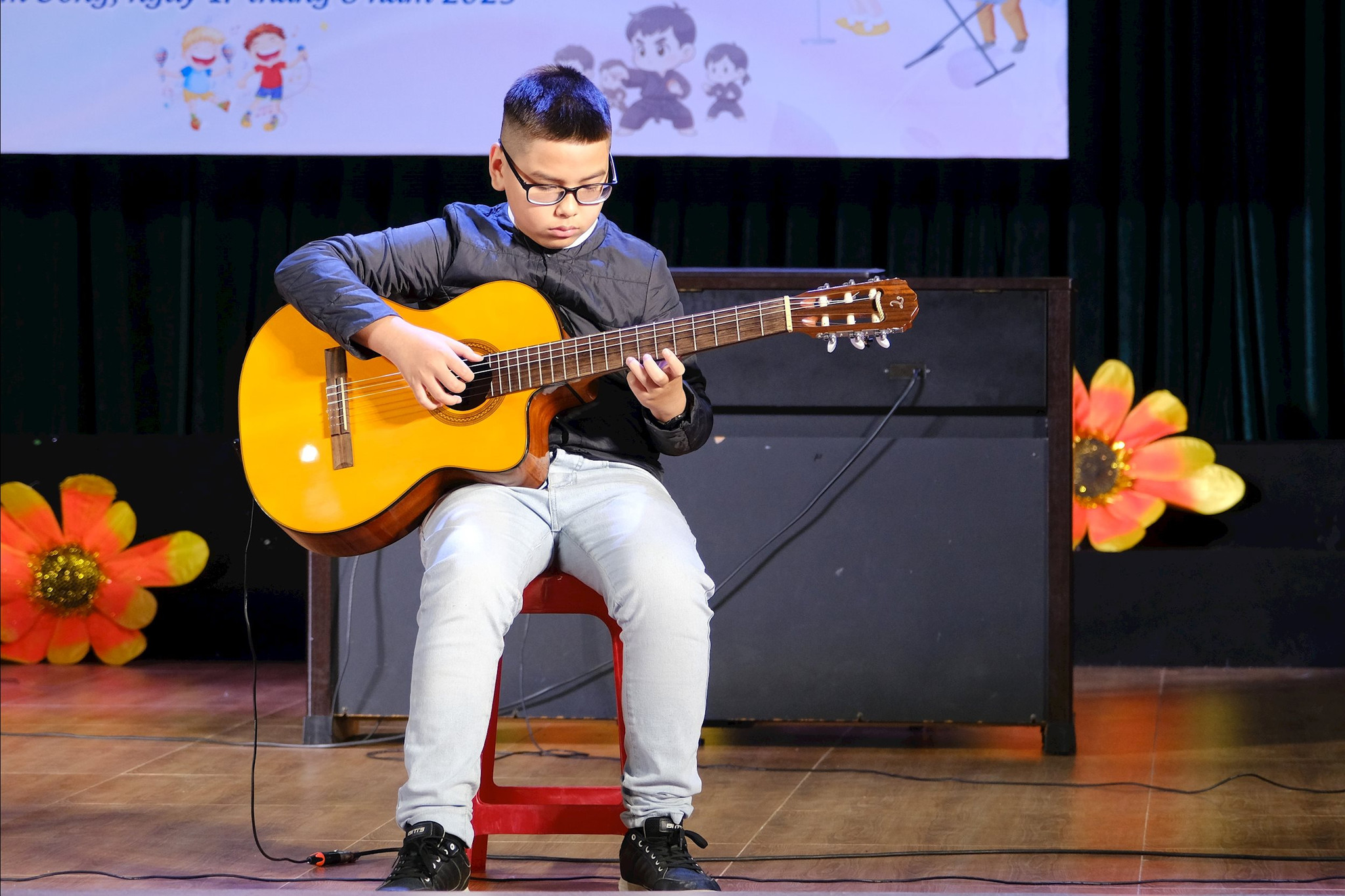 Học sinh trình diễn tiết mục guitar với nhịp điệu tự tin và tập trung