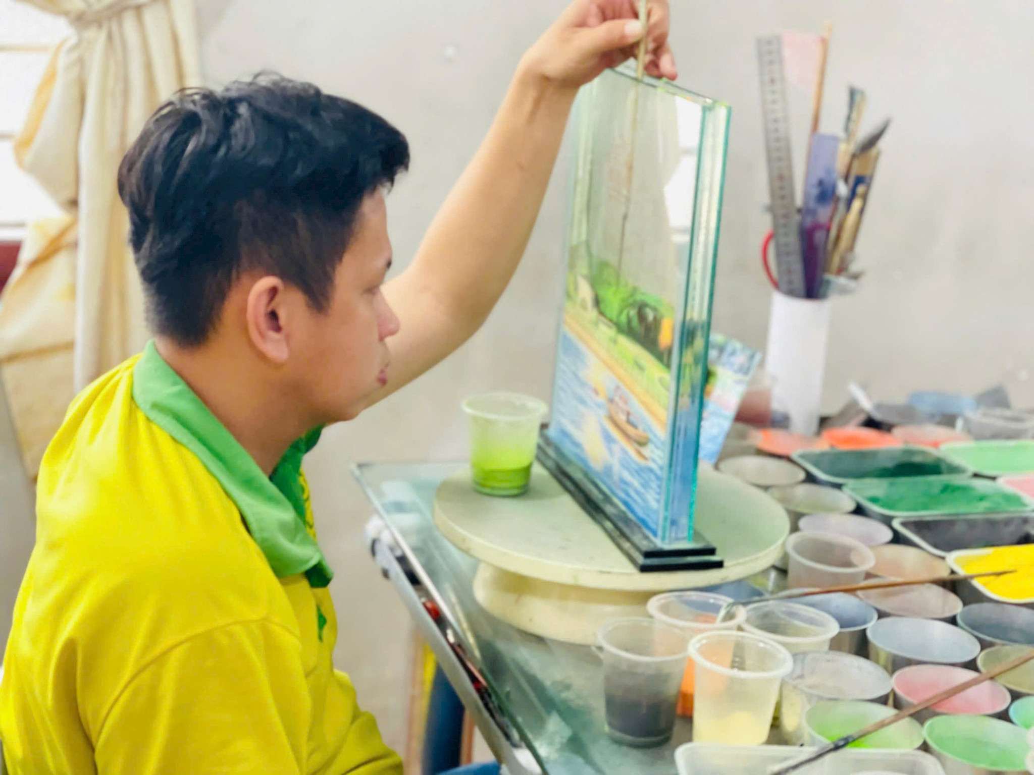 Anh Lữ Ngọc Toàn đang chú tâm vào bức tranh dù bị khiếm thính