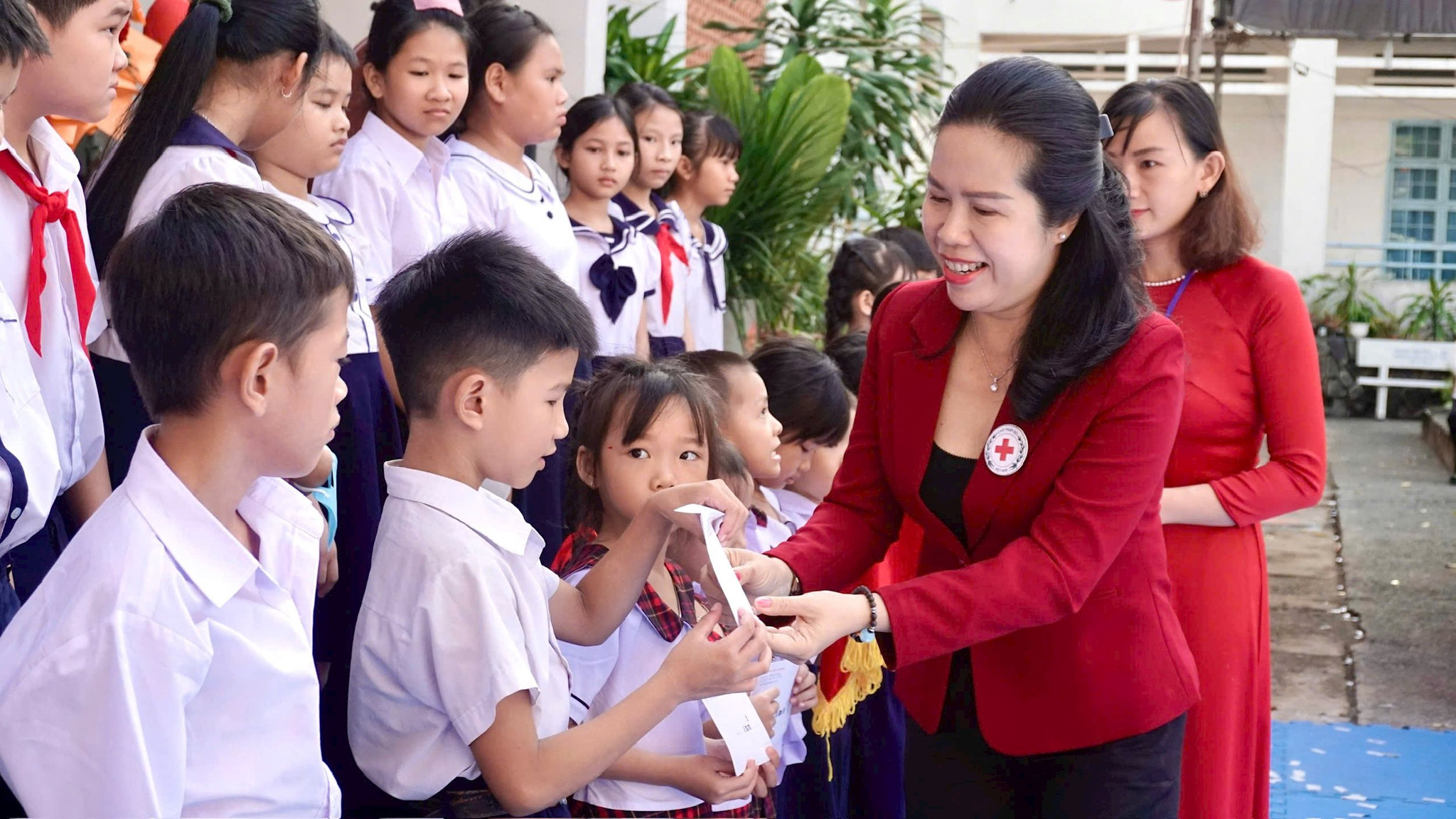 Bà Nguyễn Thị Thanh Nhàn, Đại diện lãnh đạo Hội Chữ thập đỏ tỉnh Lâm Đồng trao tặng quà cho các em học sinh có hoàn cảnh khó khăn của Trường Tiểu học Phú Tài 