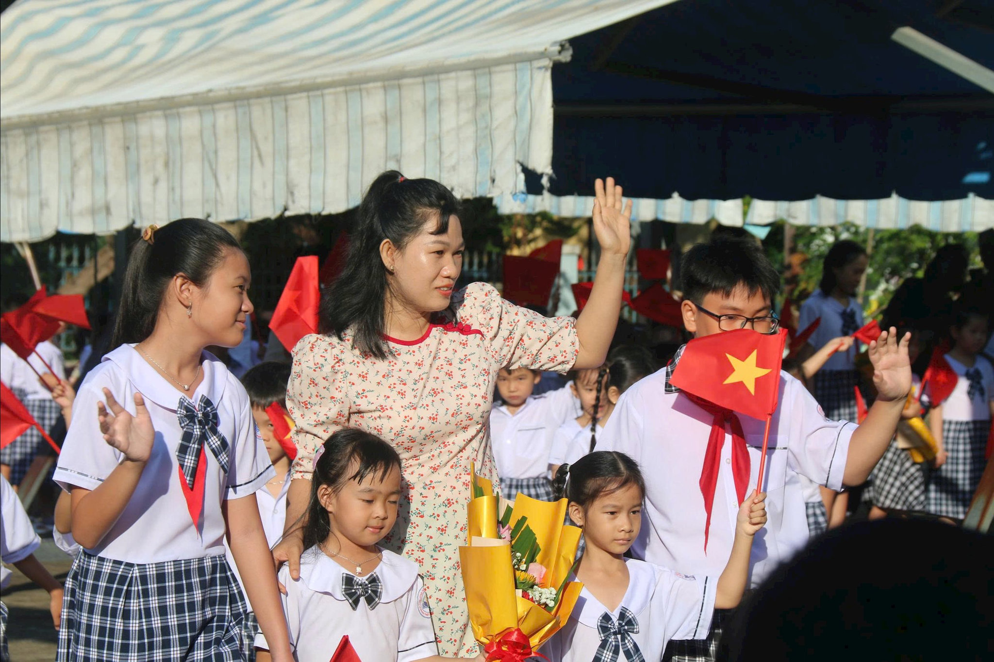 Cô Huỳnh Thị Hồng Trâm, Giáo viên chủ nhiệm lớp 1D, Trường TH Xuân An, phường Ham Thắng dẫn các em học sinh lớp 1 dự lễ khai giảng
