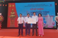 Đại diện Báo Nhân Dân trao biểu trưng 20 suất học bổng đến lãnh đạo Trường trung học phổ thông Tiền Phong. 