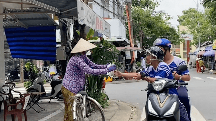 Hai bạn nam trong nhóm đi tặng suất ăn.
