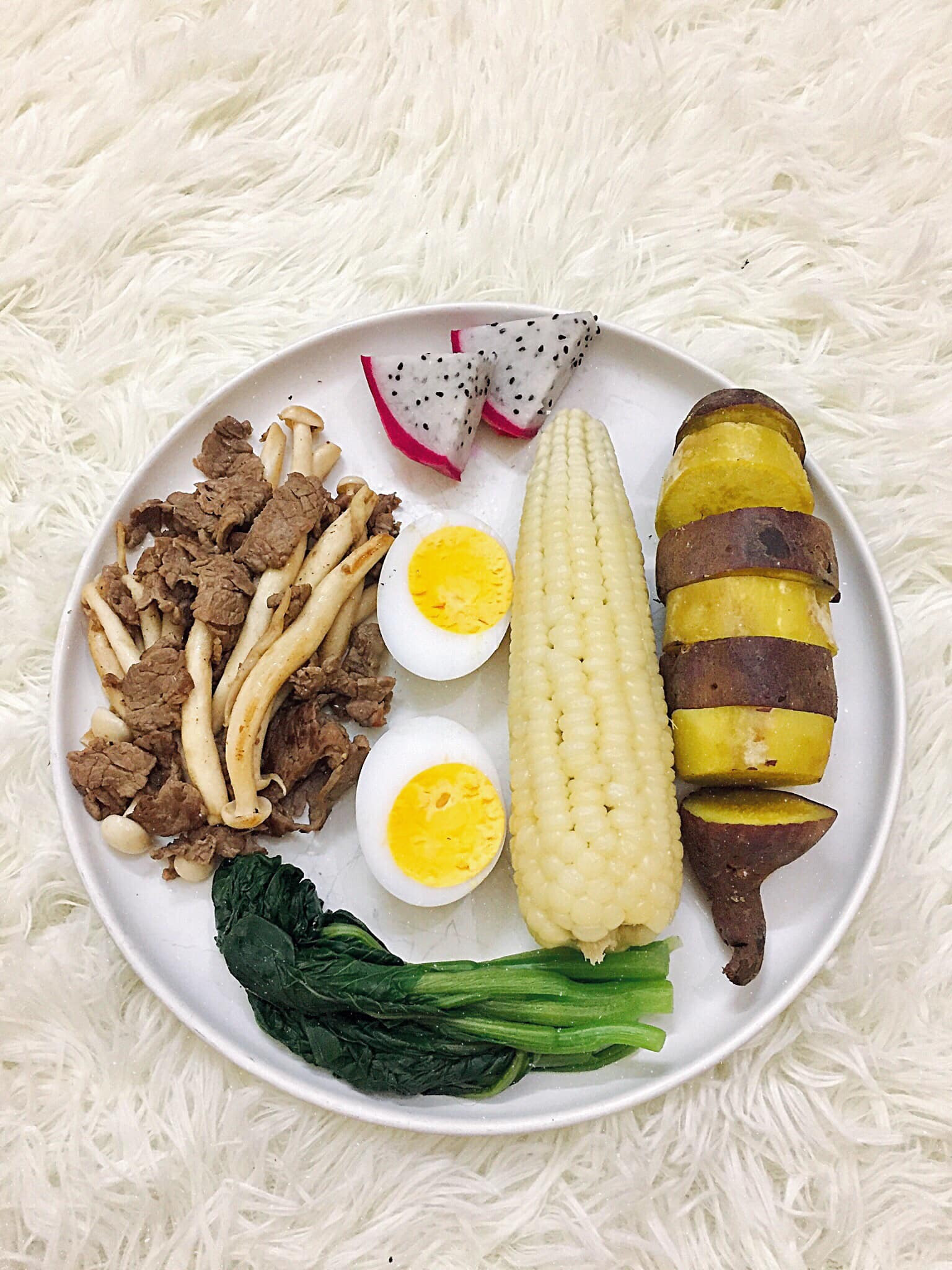 Khoai lang, ngô nếp luộc, bò xào nấm hải sản, trứng gà luộc, cải ngọt luộc, thanh long.
