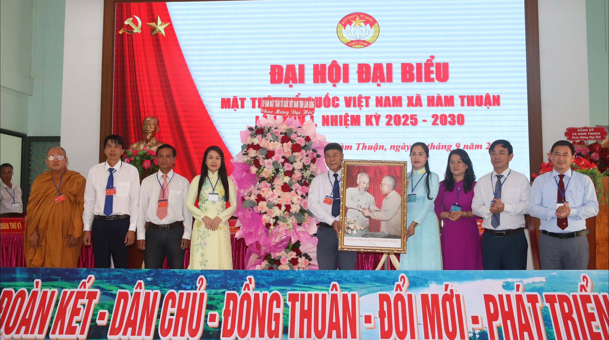 Đồng chí H’Vi Ê Ban tặng Đại hội đại biểu MTTQ Việt Nam xã Hàm Thuận lẵng hoa và bức tranh Bác Hồ và Bác Tôn 