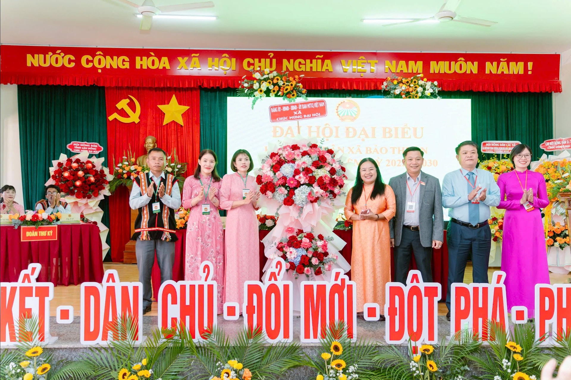 Para pemimpin komune Bao Thuan mempersembahkan bunga untuk memberi ucapan selamat kepada Kongres