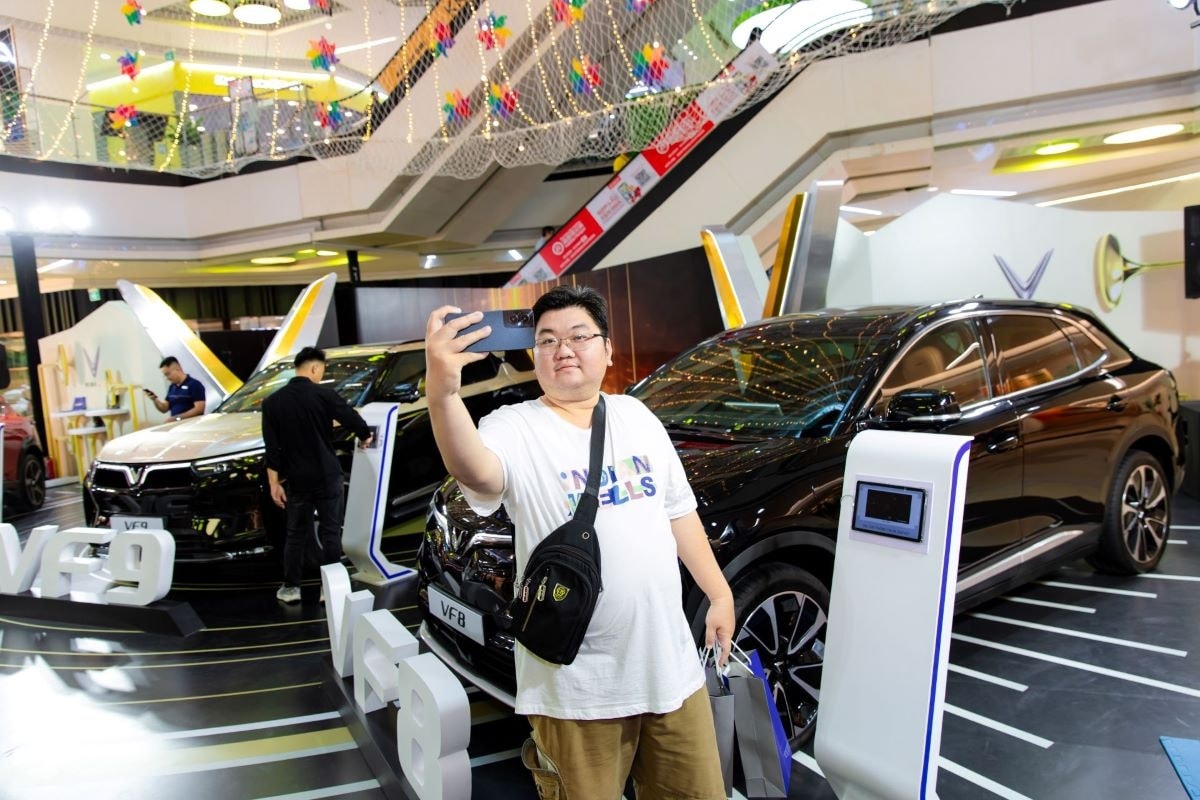Khách hàng chụp ảnh cùng bộ ba xe điện VinFast tại sự kiện.