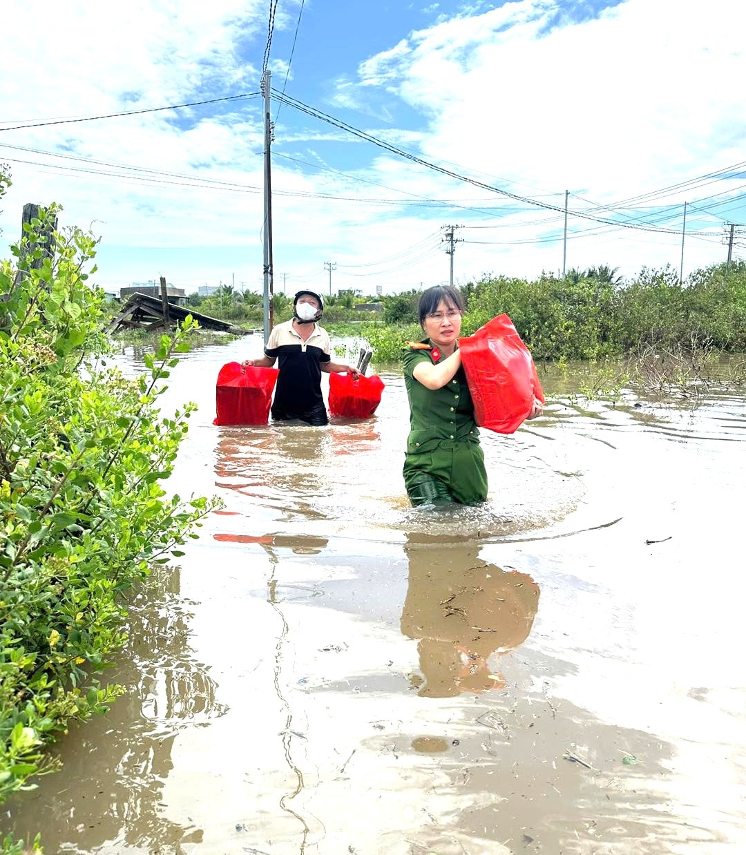 Agenten van de politie van de gemeente Ham Liem bezorgen geschenken en benodigdheden aan mensen in het gebied dat getroffen is door de overstromingen.
