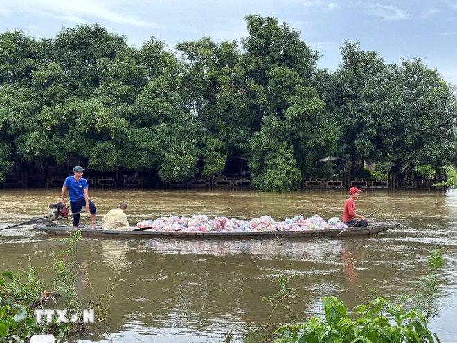 Các đoàn tình nguyện vận chuyển hàng hóa lên ghe để đưa vào những vùng ngập sâu ở thành phố Huế. (Ảnh: Đỗ Trưởng/TTXVN) ttxvn-3010-ho-tro-nguoi-dan-vung-lu-hue-2.jpg