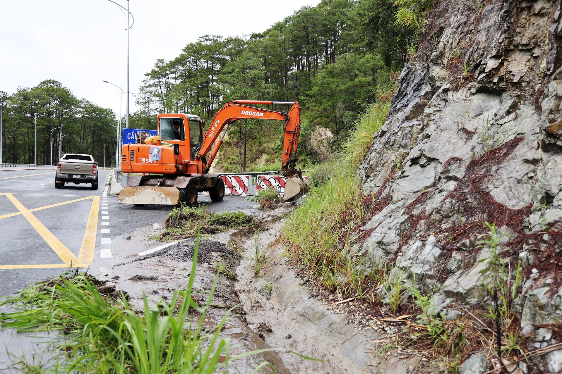 Рабочие прочищают канализацию, заваленную камнями и деревьями
