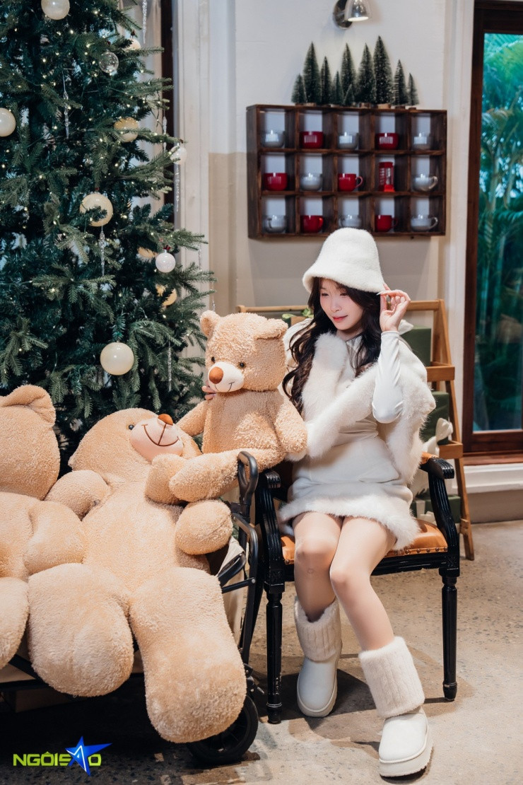Một bạn nữ tạo dáng chụp ảnh trong trang phục màu đỏ nổi bật trên nền tuyết trắng.