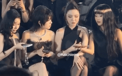 Các khách mời khác đang chụp ảnh trong khi Bích Phương ngồi quan sát tại sự kiện.