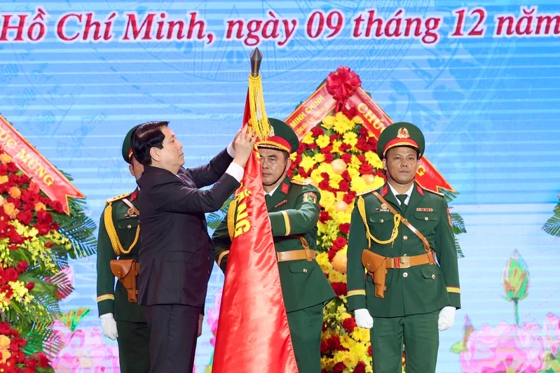 Chủ tịch nước Lương Cường gắn huy hiệu Anh hùng LLVT nhân dân lên Quân kỳ Quyết thắng Quân khu 7.