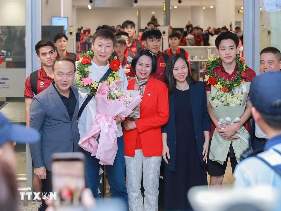 Phó Cục trưởng Cục Thể dục Thể thao Lê Thị Hoàng Yến tặng hoa chúc mừng huấn luyện viên Kim Sang-sik và đội tuyển bóng đá nam U22 Việt Nam.(Ảnh: Phan Phương/TTXVN)
