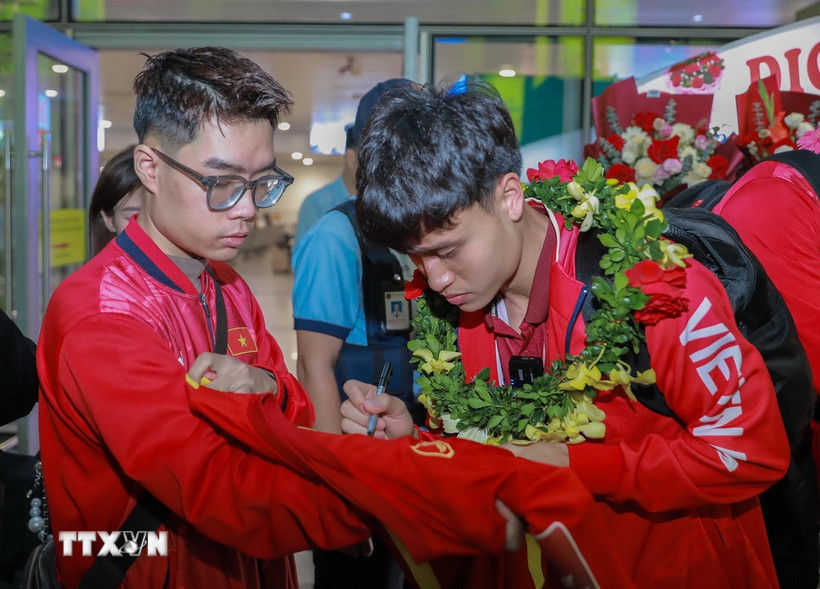 Cầu thủ đội tuyển bóng đá U22 Việt Nam ký tặng người hâm mộ. (Ảnh: Phan Phương/TTXVN)