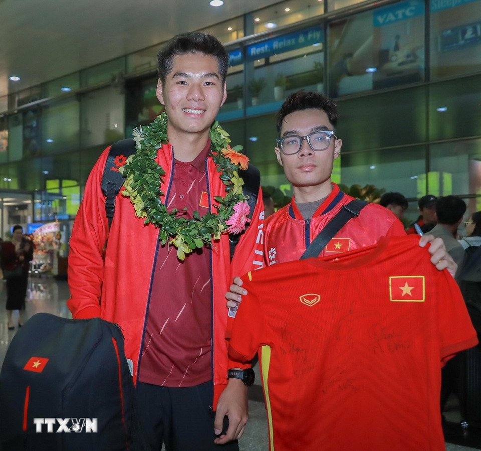 Người hâm mộ chụp ảnh lưu niệm cùng cầu thủ đội tuyển bóng đá nam U22 Việt Nam. (Ảnh: Phan Phương/TTXVN)